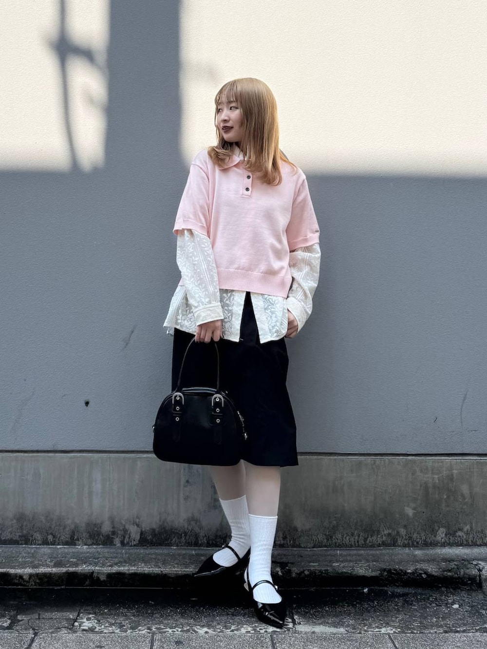ブラック系のパンプス、ホワイト系のシャツ/ブラウス、ブラック系のスラックスを着用したレディースの春コーディネートの4枚目の写真