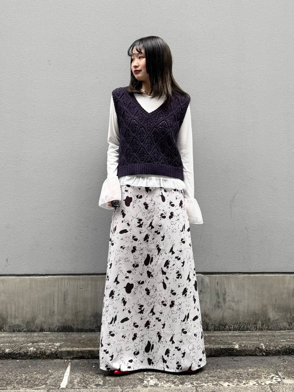 レッド系のパンプス、ブラウン系のスカート、ホワイト系のTシャツ/カットソーを着用したレディースの春コーディネートの2枚目の写真