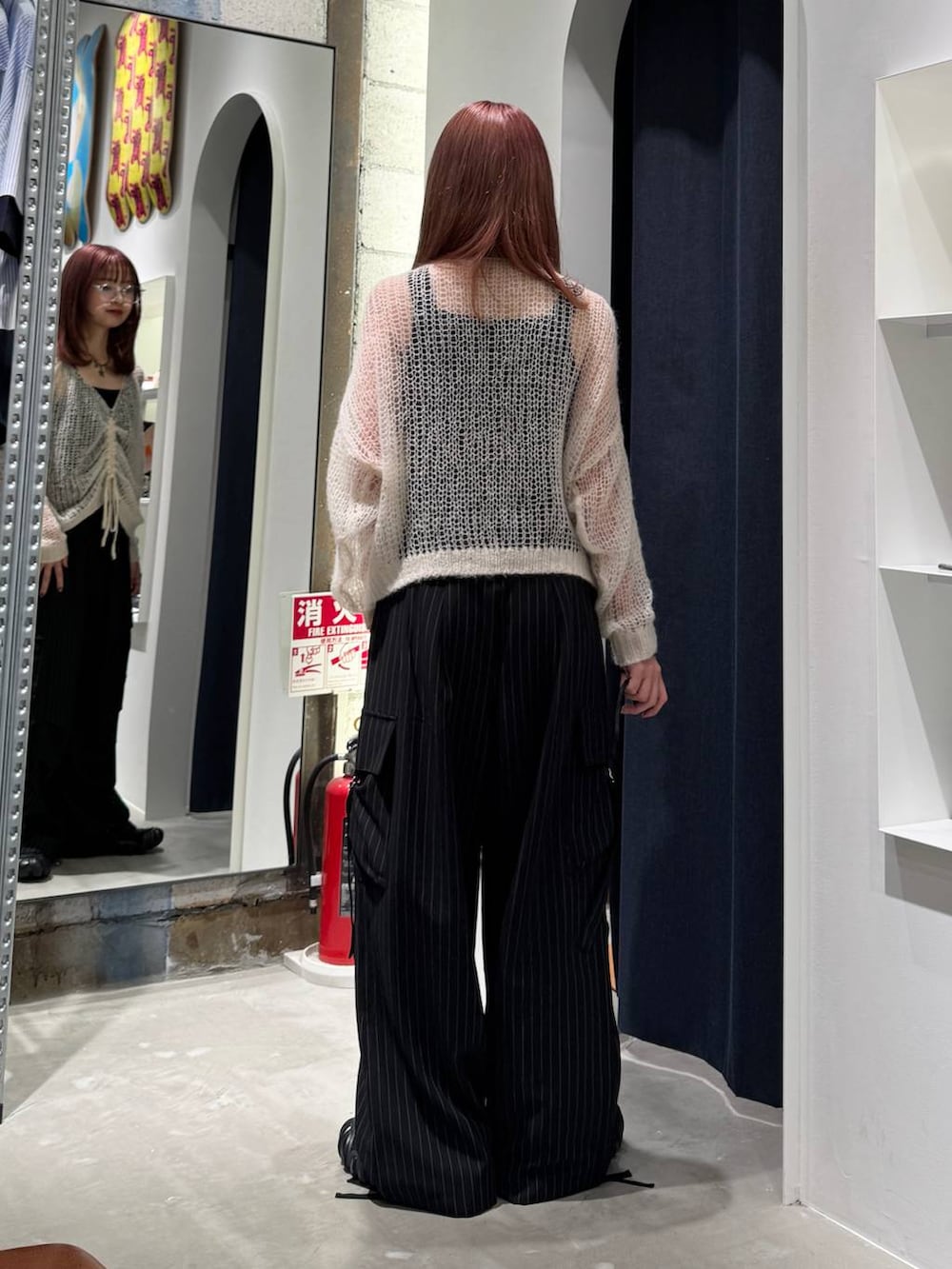 ホワイト系のニット/セーター、ブラック系のカーゴパンツ、ブラック系のタンクトップを着用したレディースの秋コーディネートの6枚目の写真