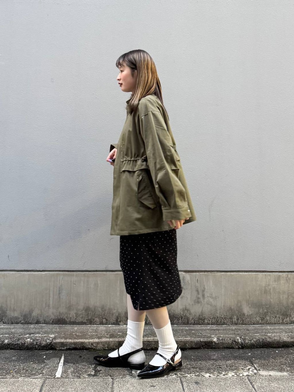 ブラック系のパンプス、イエロー系のショルダーバッグ、ブラック系のワンピースを着用したレディースの春コーディネートの5枚目の写真