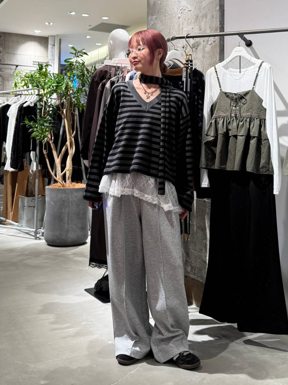 ホワイト系のTシャツ/カットソー、ブラック系のニット/セーター、グレー系のスウェットパンツを着用したレディースの秋コーディネートの5枚目の写真