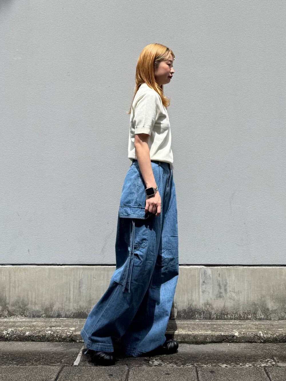 ブルー系のデニムパンツ、ホワイト系のポロシャツを着用したレディースの春コーディネートの7枚目の写真