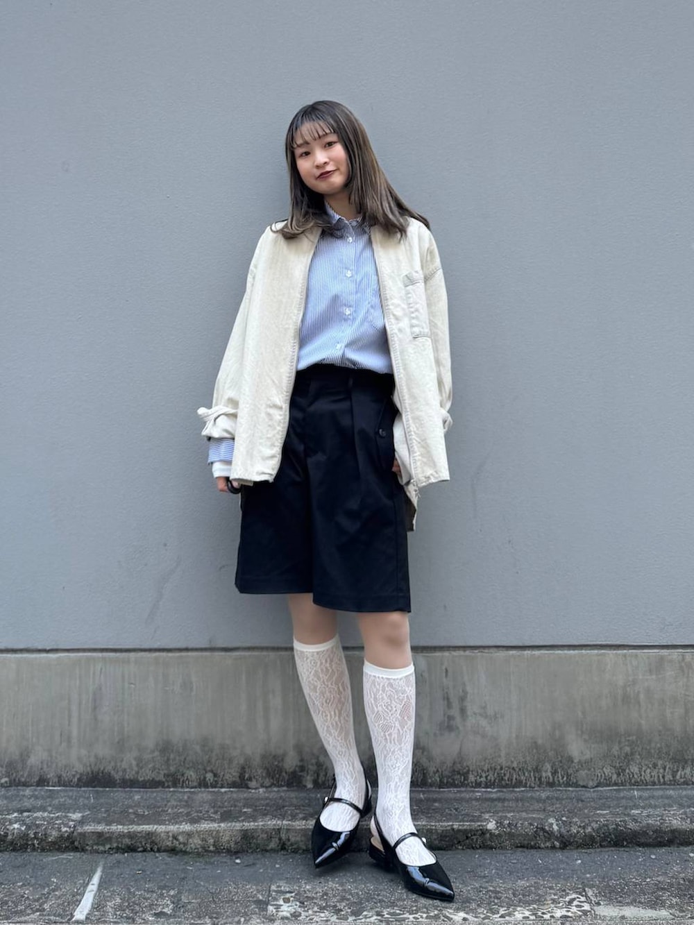 ブラック系のパンプス、ブラック系のスラックス、ブルー系のシャツ/ブラウスを着用したレディースの春コーディネートの3枚目の写真