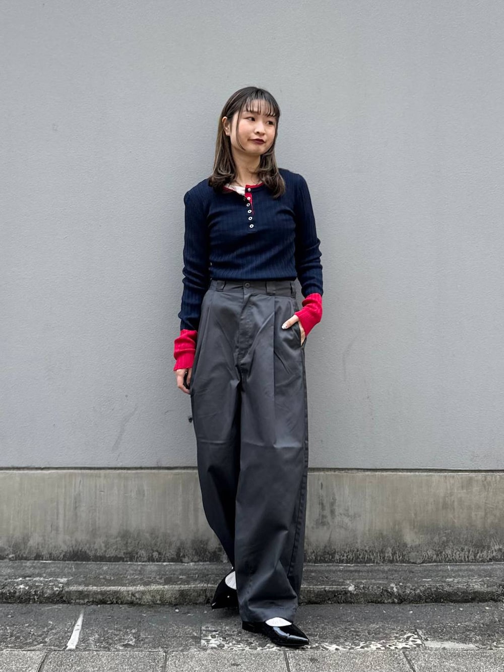 グレー系のチノパンツ、ブラック系のパンプス、ブルー系のニット/セーターを着用したレディースの春コーディネートの4枚目の写真