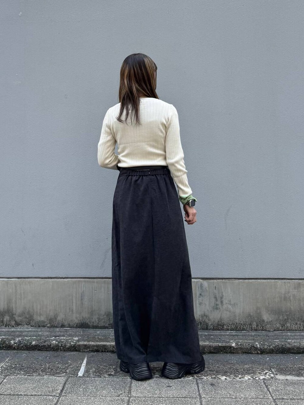 ブラック系のローファー、ブラック系のスカート、ホワイト系のニット/セーターを着用したレディースの春コーディネートの6枚目の写真