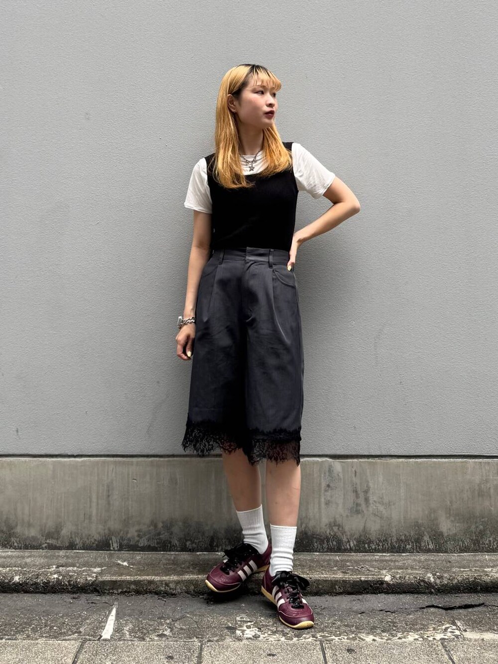 ブラック系のタンクトップ、ホワイト系のTシャツ/カットソー、ブラック系のスラックスを着用したレディースの夏コーディネートの2枚目の写真