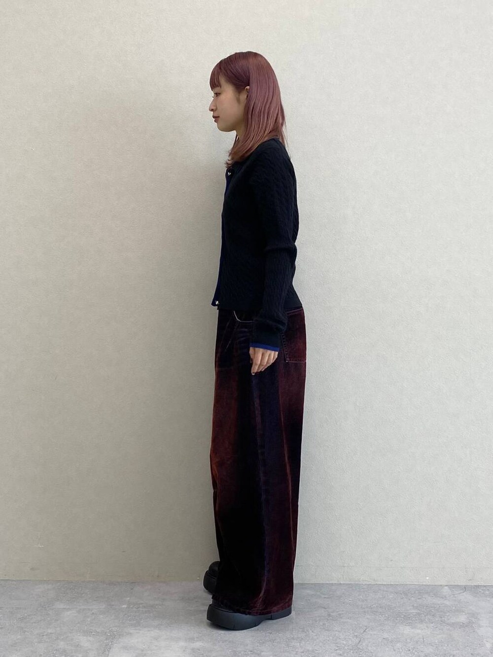 レッド系のデニムパンツ、ブラック系のニット/セーターを着用したレディースの秋コーディネートの5枚目の写真