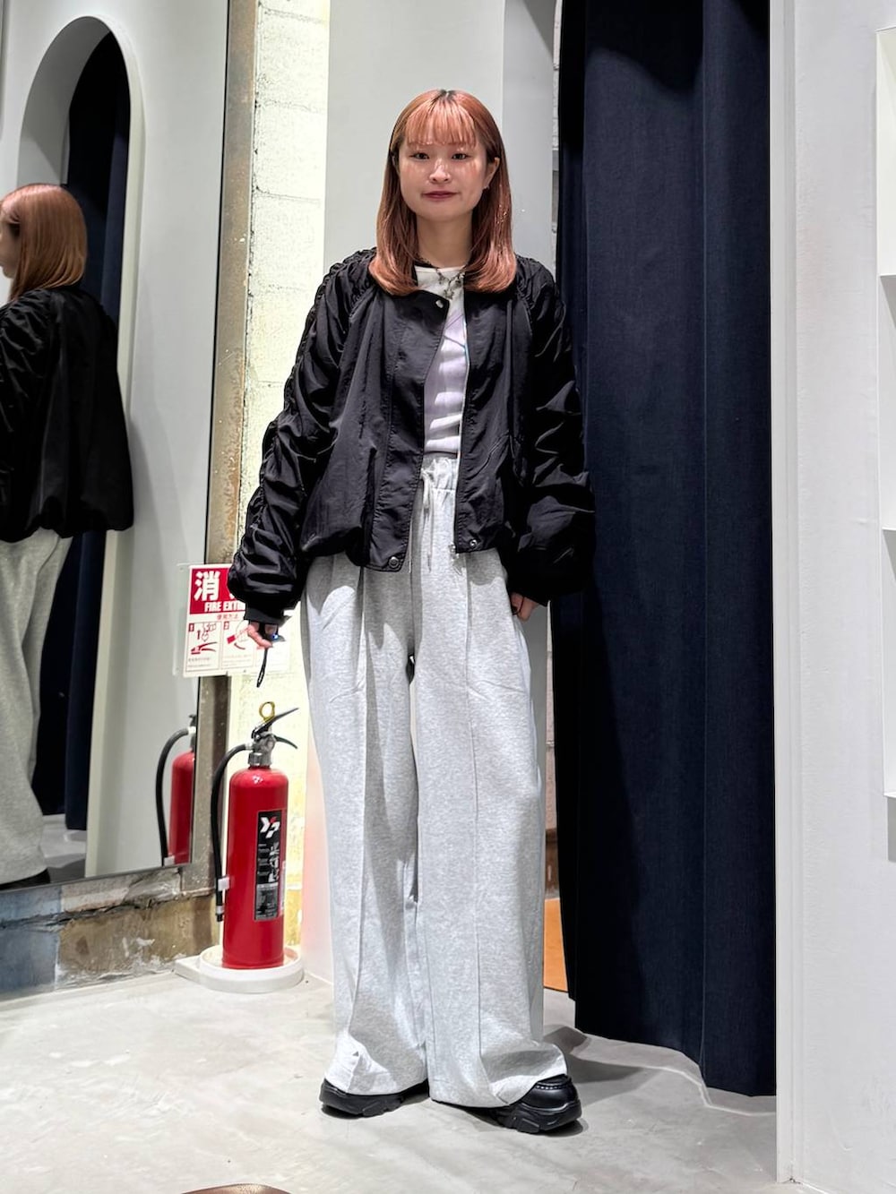 ブラック系のMA-1、ホワイト系のTシャツ/カットソー、グレー系のスウェットパンツを着用したレディースの秋コーディネートの2枚目の写真