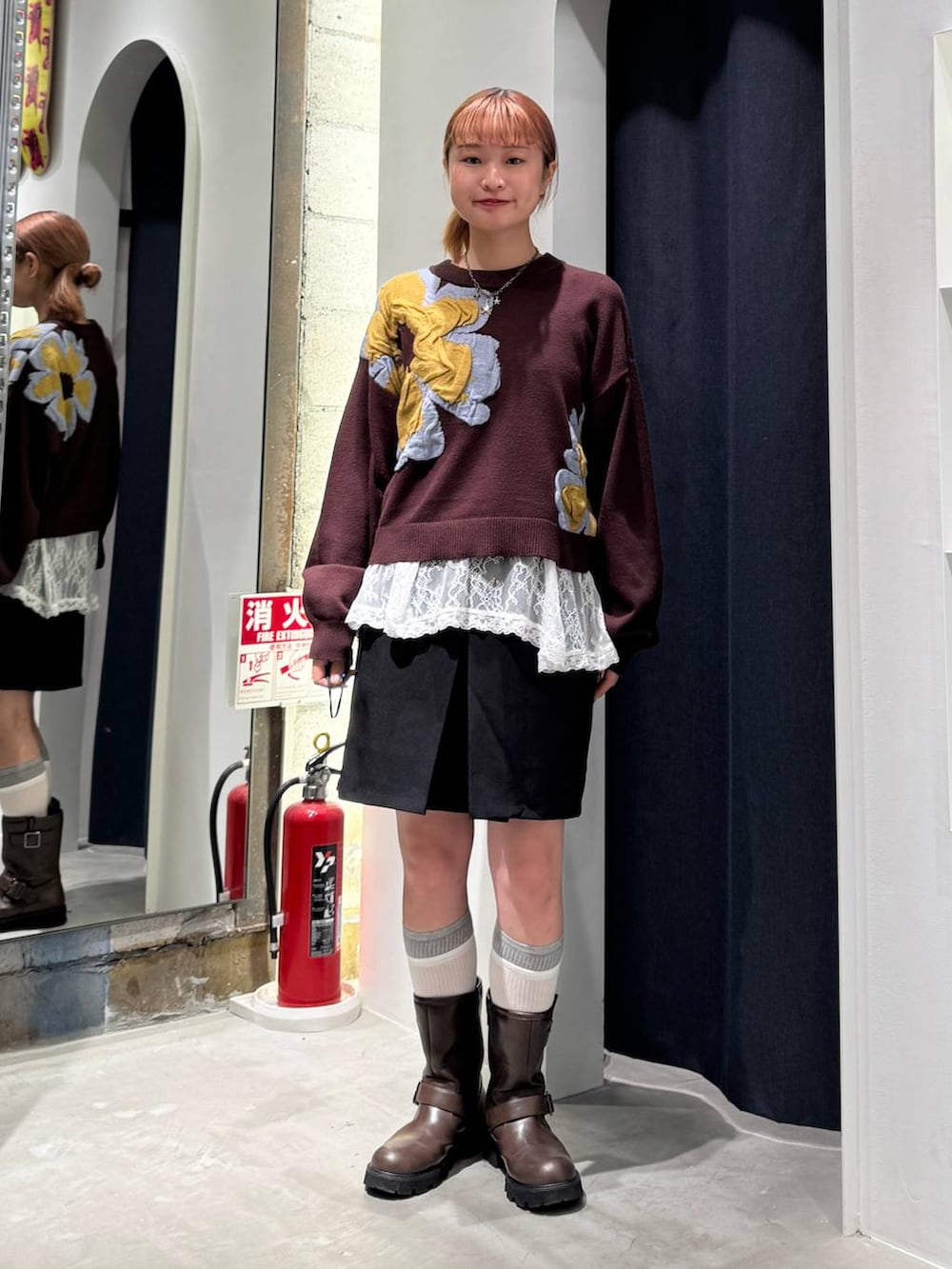ホワイト系のTシャツ/カットソー、ブラウン系のニット/セーター、ブラック系のスカートを着用したレディースの秋コーディネートの4枚目の写真