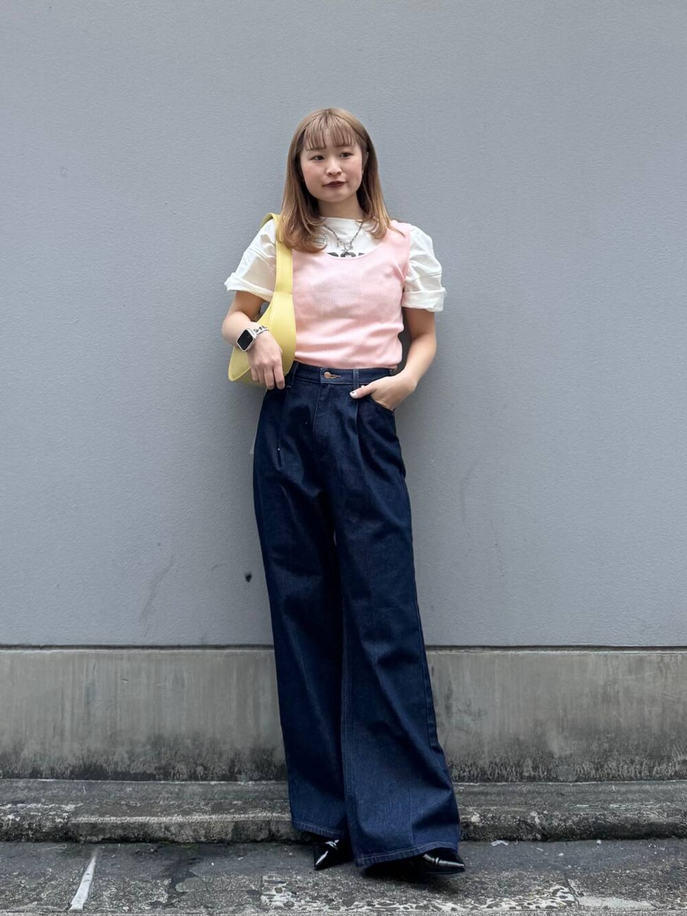 ブルー系のデニムパンツ、ホワイト系のTシャツ/カットソー、ブラック系のパンプスを着用したレディースの春コーディネートの3枚目の写真