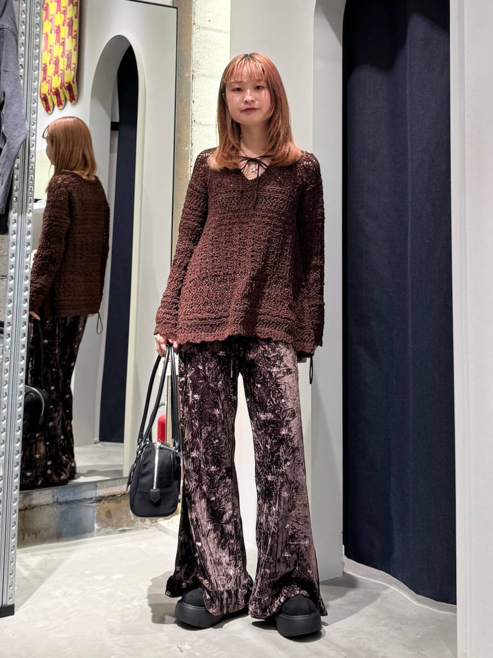 ブラウン系のその他パンツ、ブラック系のブーツ、ブラック系のショルダーバッグを着用したレディースの秋コーディネートの2枚目の写真