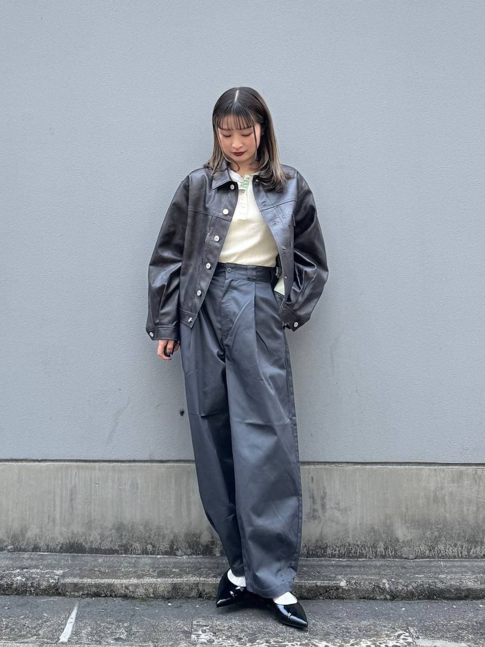 グレー系のチノパンツ、レッド系のパンプス、ブラウン系のブルゾンを着用したレディースの春コーディネートの2枚目の写真