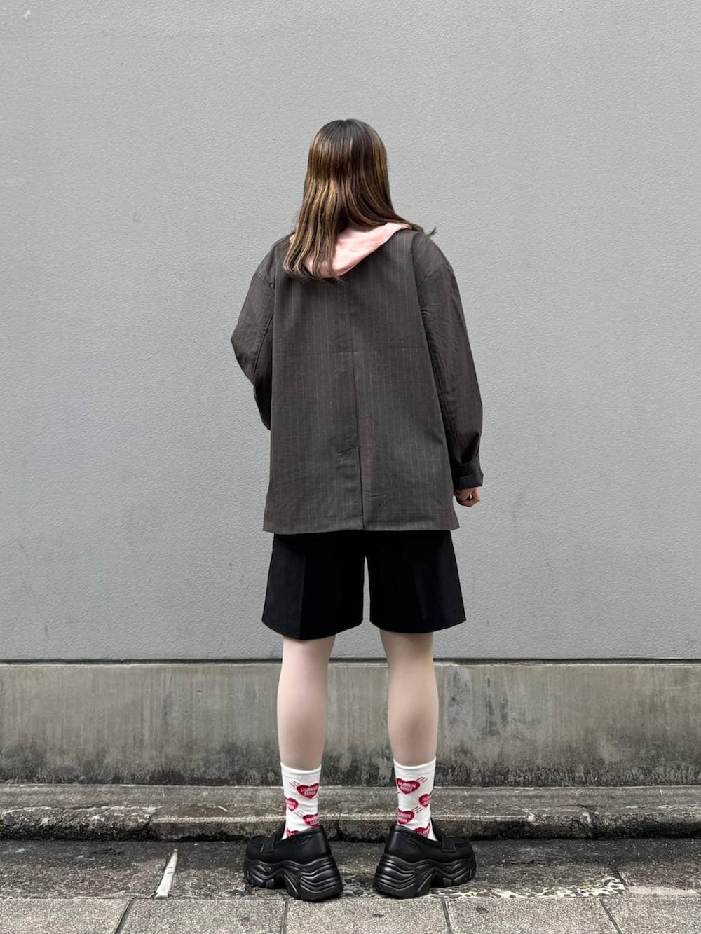 ブラック系のテーラードジャケット、ブラック系のローファー、ブラック系のスラックスを着用したレディースの春コーディネートの6枚目の写真