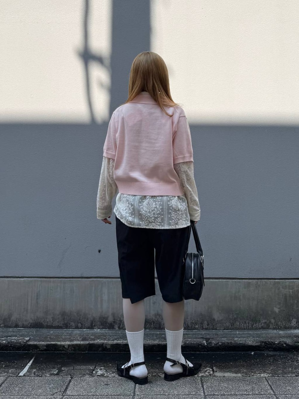 ブラック系のパンプス、ホワイト系のシャツ/ブラウス、ブラック系のスラックスを着用したレディースの春コーディネートの7枚目の写真