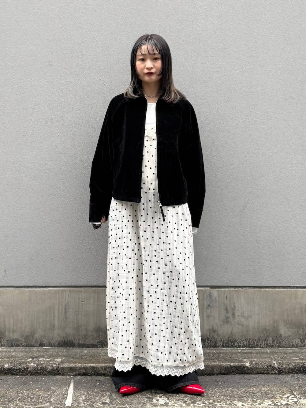 レッド系のパンプス、ブラック系のデニムパンツ、ブラック系のブルゾンを着用したレディースの春コーディネートの3枚目の写真