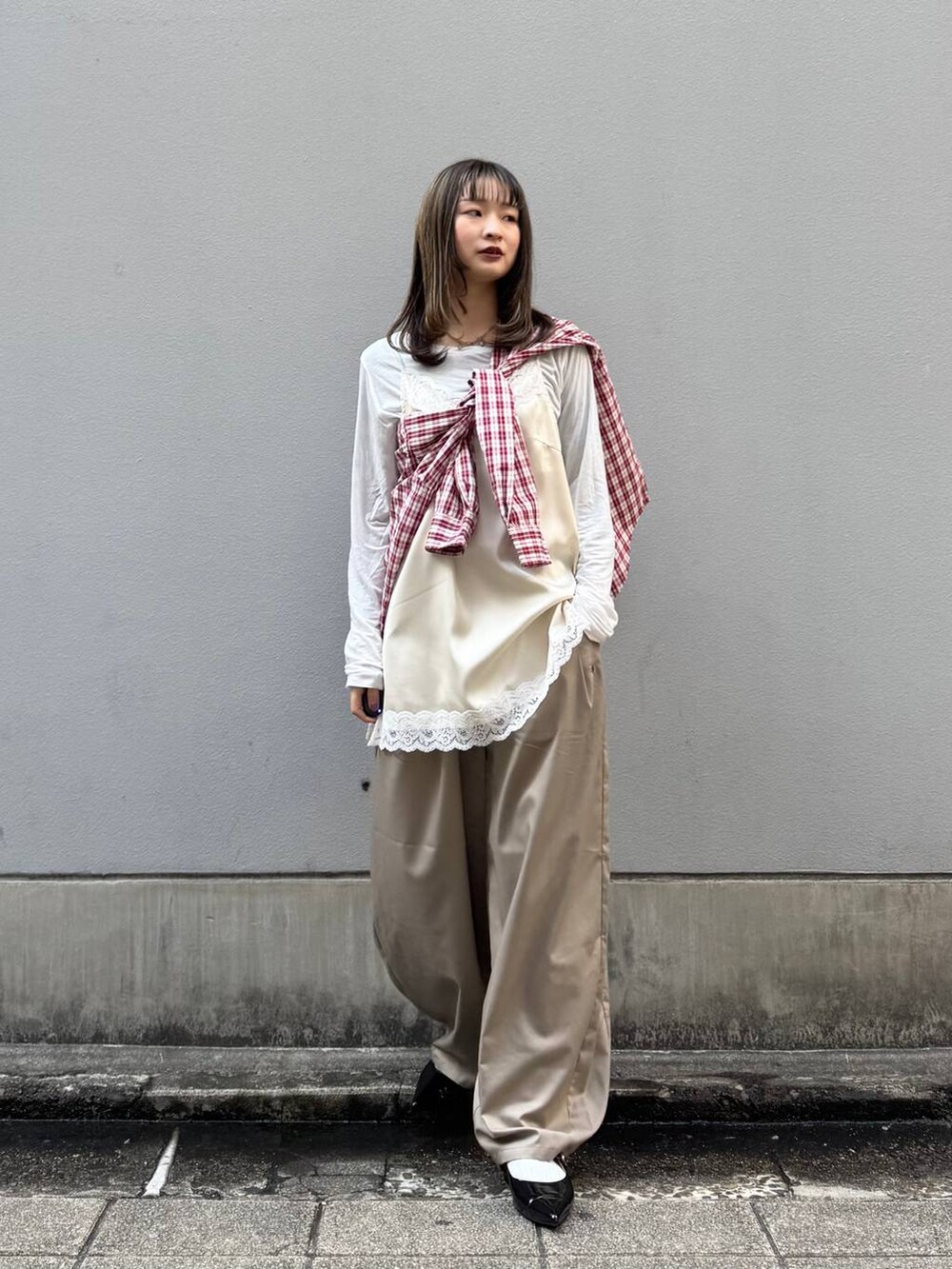 ブラック系のパンプス、ホワイト系のキャミソール、ベージュ系のスラックスを着用したレディースの春コーディネートの4枚目の写真