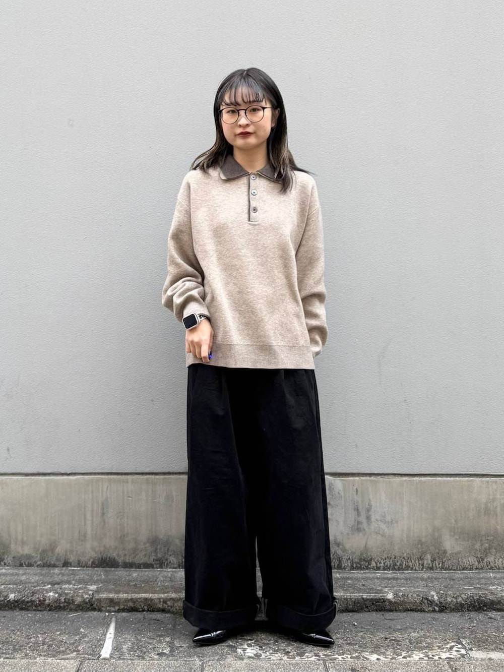 ブラック系のパンプス、ブラック系のチノパンツ、ベージュ系のニット/セーターを着用したレディースの春コーディネートの2枚目の写真