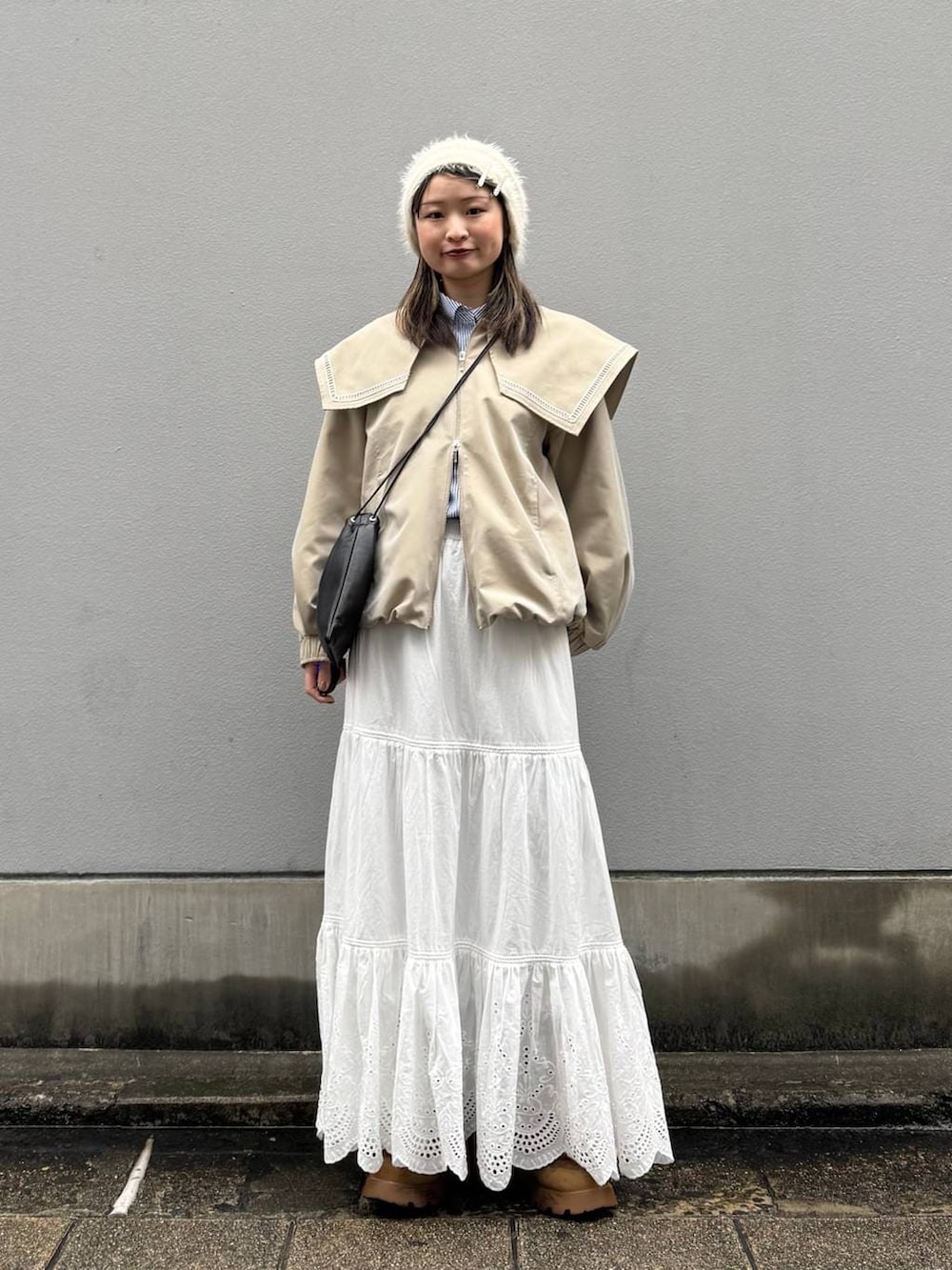 ブラック系のショルダーバッグ、ベージュ系のブルゾン、ブルー系のシャツ/ブラウスを着用したレディースの春コーディネートの3枚目の写真