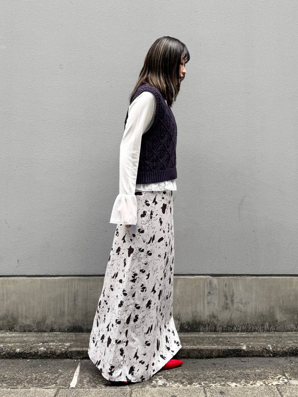 レッド系のパンプス、ブラウン系のスカート、ホワイト系のTシャツ/カットソーを着用したレディースの春コーディネートの7枚目の写真