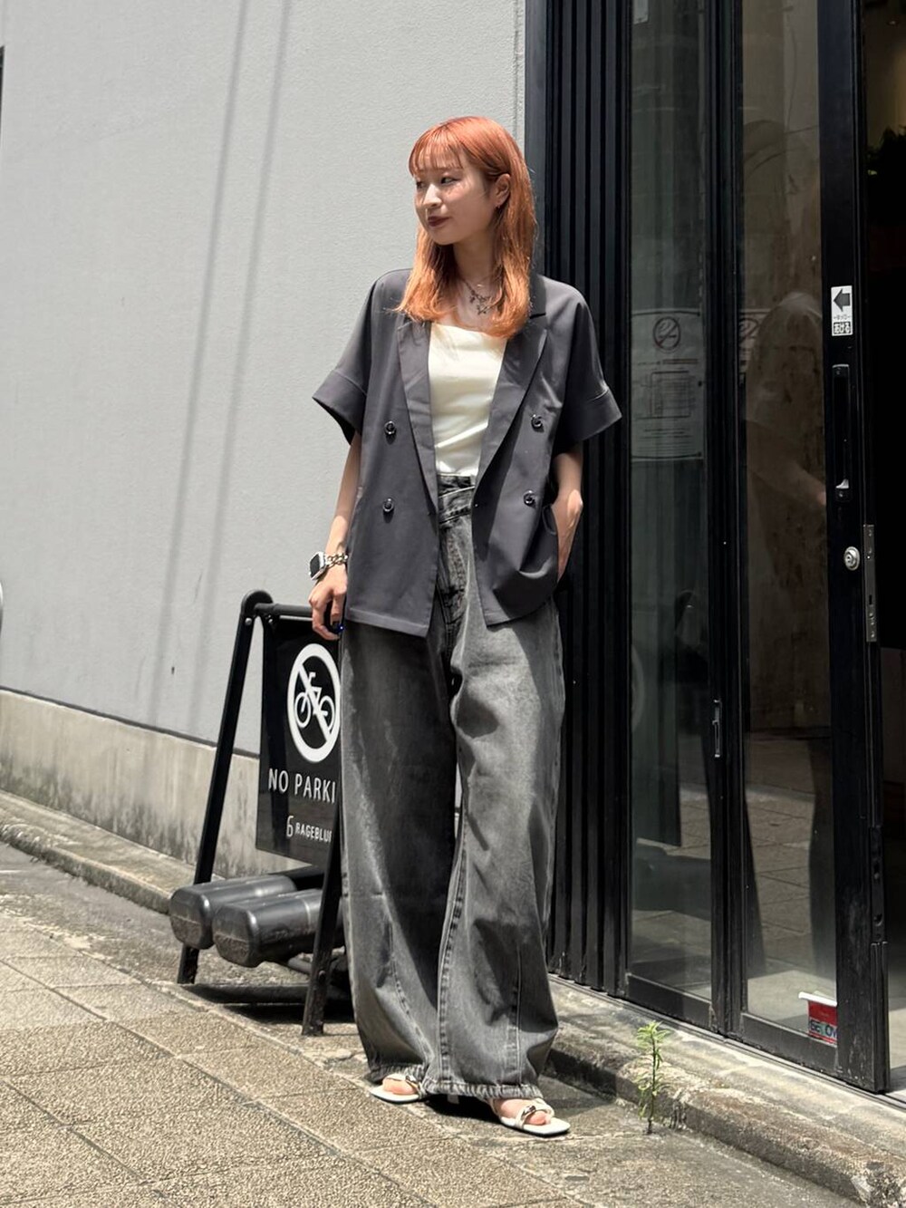 グレー系のデニムパンツ、グレー系のテーラードジャケット、ホワイト系のキャミソールを着用したレディースの夏コーディネートの3枚目の写真