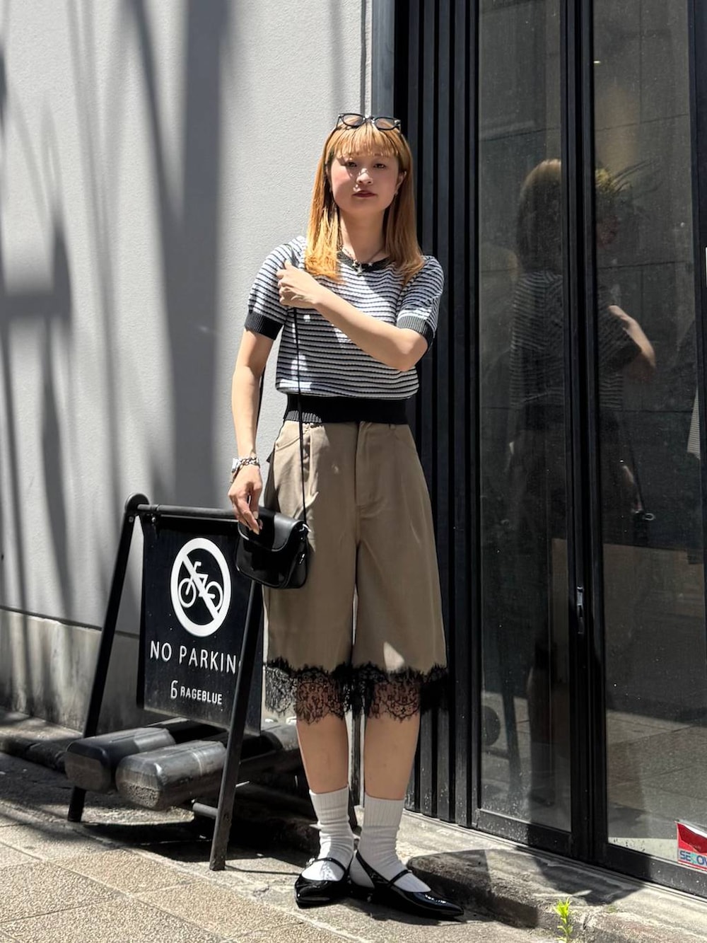 ブラック系のパンプス、グレー系のニット/セーター、ブラック系のショルダーバッグを着用したレディースの春コーディネートの5枚目の写真
