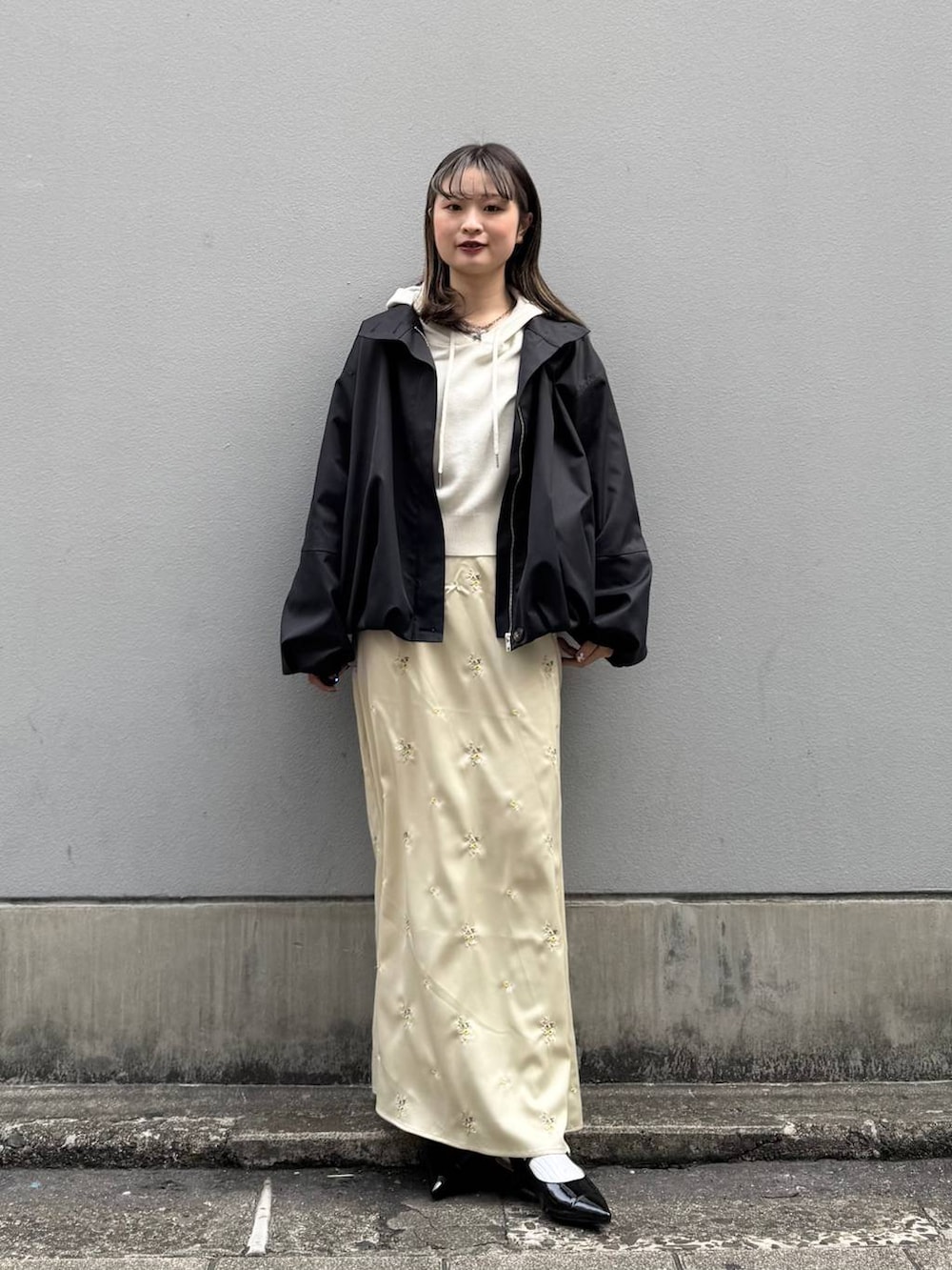 ブラック系のパンプス、ホワイト系のパーカー、ブラック系のブルゾンを着用したレディースの春コーディネートの3枚目の写真