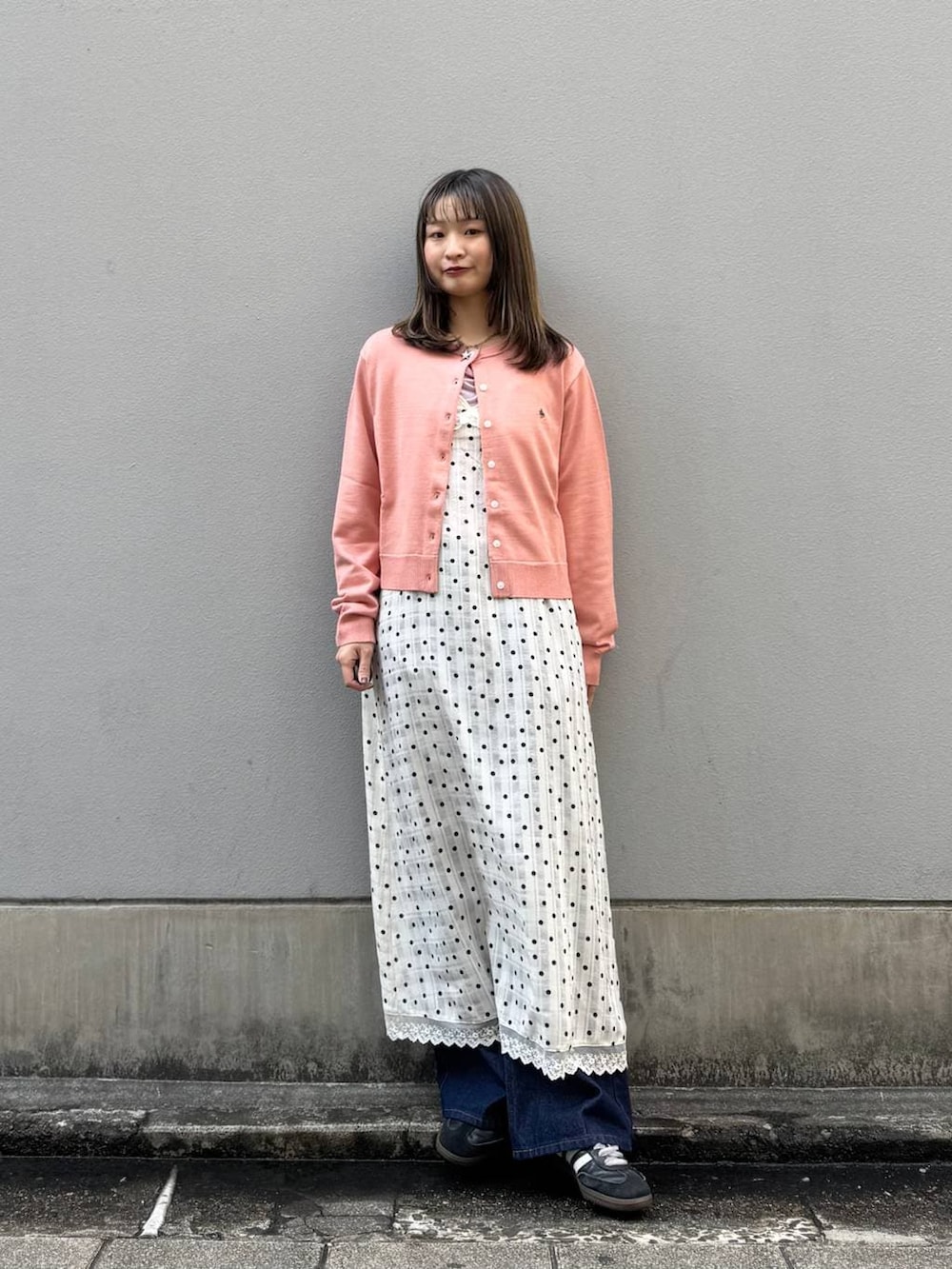 ブルー系のデニムパンツ、ホワイト系のワンピース、ピンク系のTシャツ/カットソーを着用したレディースの春コーディネートの2枚目の写真