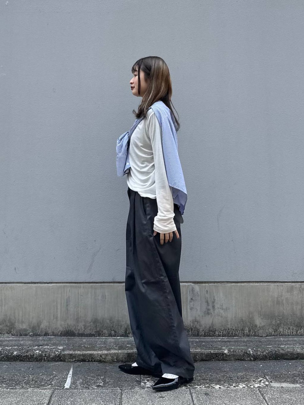 グレー系のチノパンツ、ブラック系のパンプス、ブルー系のシャツ/ブラウスを着用したレディースの春コーディネートの5枚目の写真