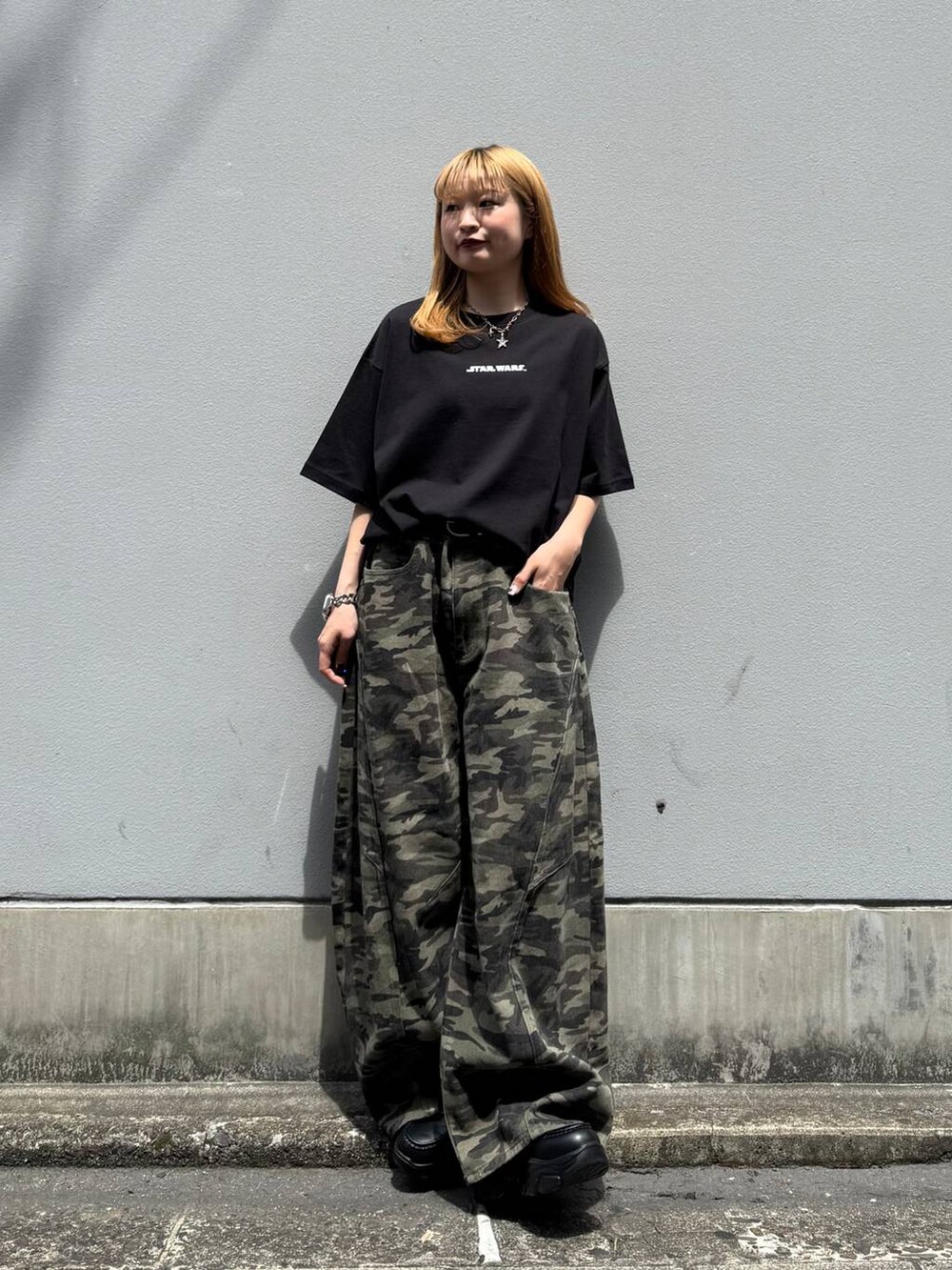 ブラック系のローファー、ブラック系のTシャツ/カットソー、グリーン系のデニムパンツを着用したレディースの春コーディネートの3枚目の写真