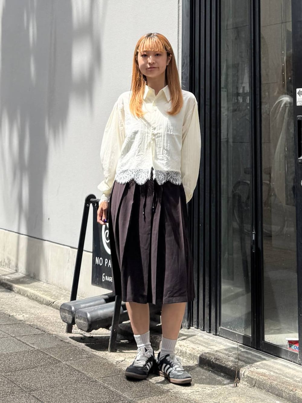 ブラウン系のスカート、ホワイト系のシャツ/ブラウスを着用したレディースの夏コーディネートの2枚目の写真