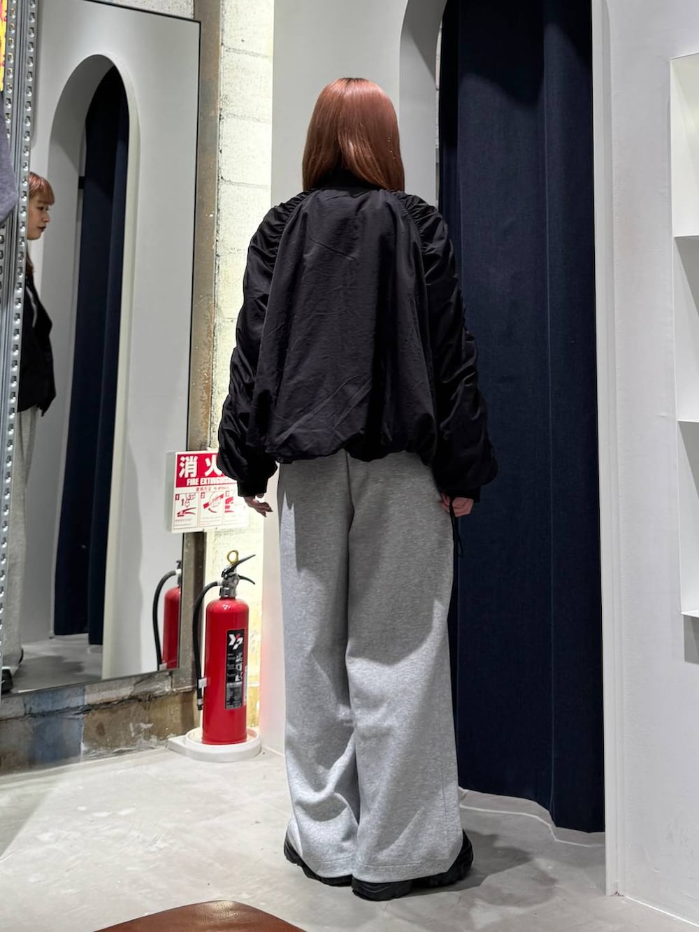 ブラック系のMA-1、ホワイト系のTシャツ/カットソー、グレー系のスウェットパンツを着用したレディースの秋コーディネートの6枚目の写真