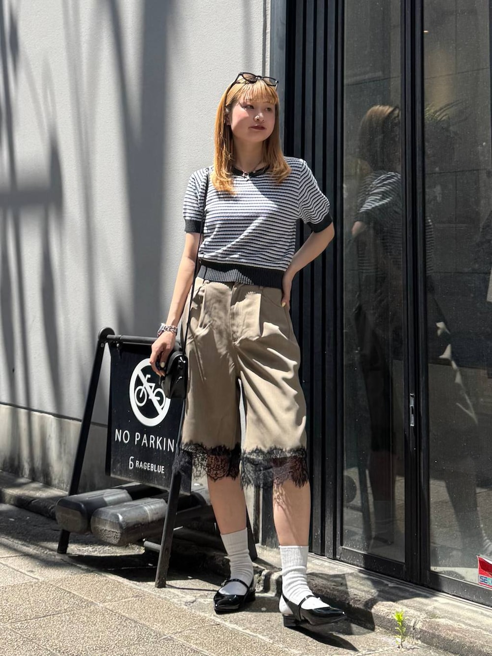 ブラック系のパンプス、グレー系のニット/セーター、ブラック系のショルダーバッグを着用したレディースの春コーディネートの2枚目の写真