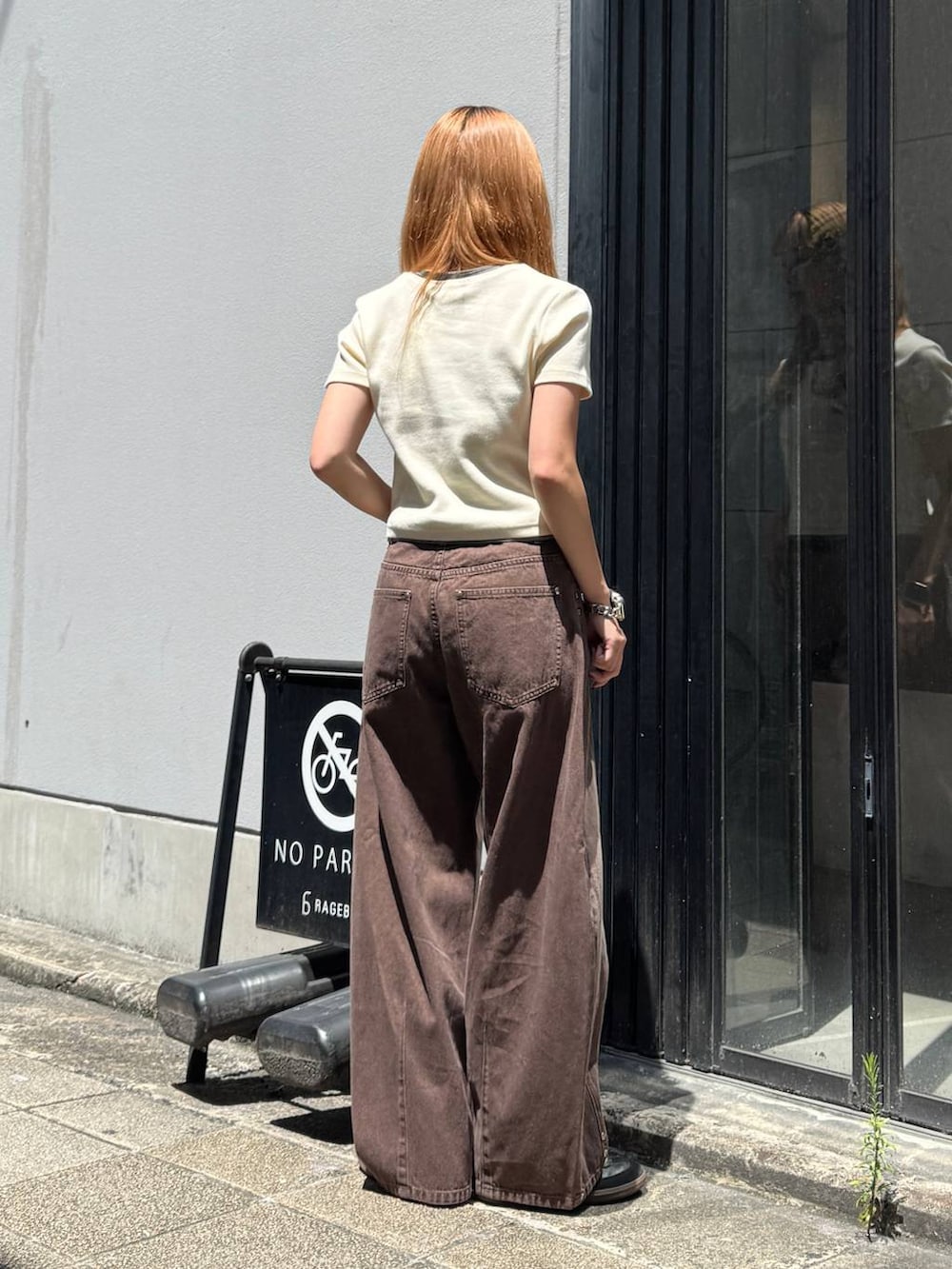 ブラウン系のデニムパンツ、ホワイト系のTシャツ/カットソーを着用したレディースの夏コーディネートの5枚目の写真