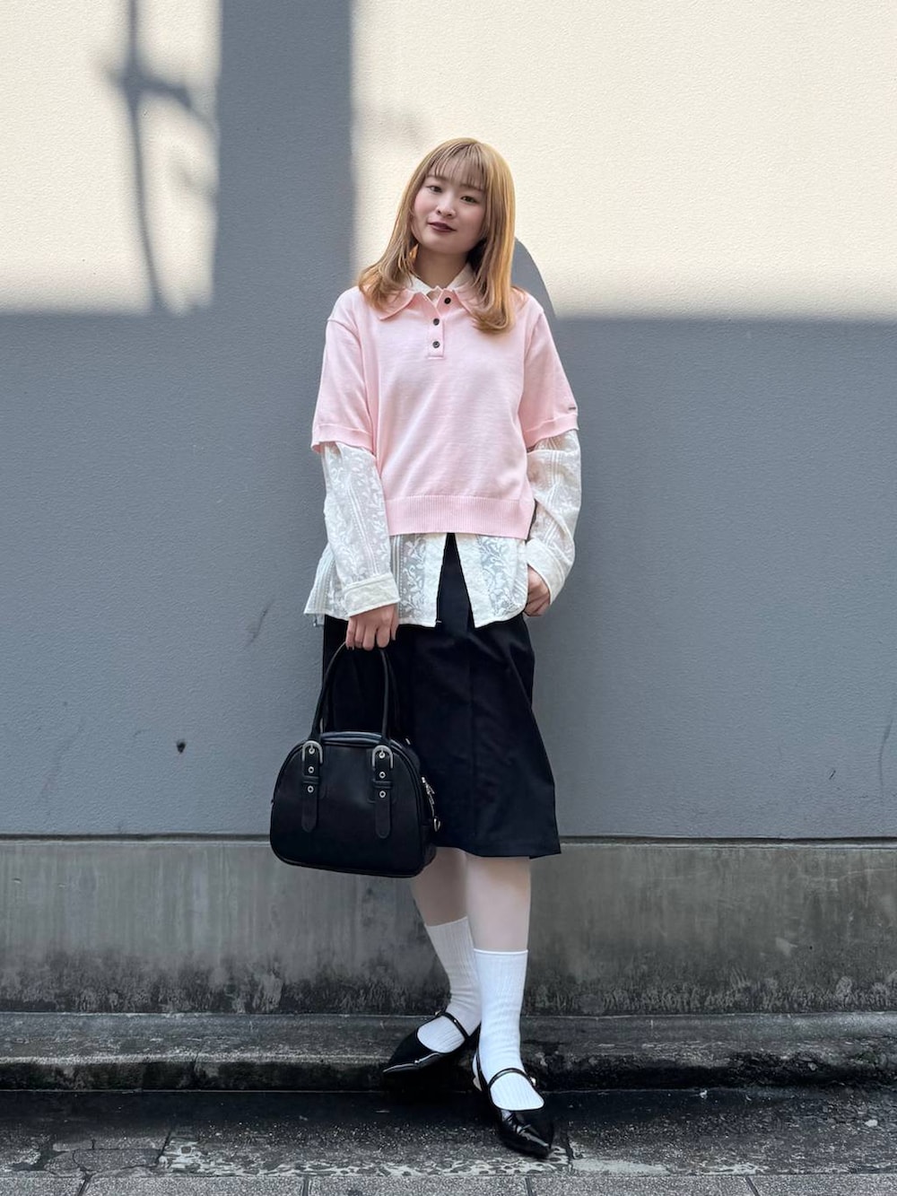 ブラック系のパンプス、ホワイト系のシャツ/ブラウス、ブラック系のスラックスを着用したレディースの春コーディネートの5枚目の写真