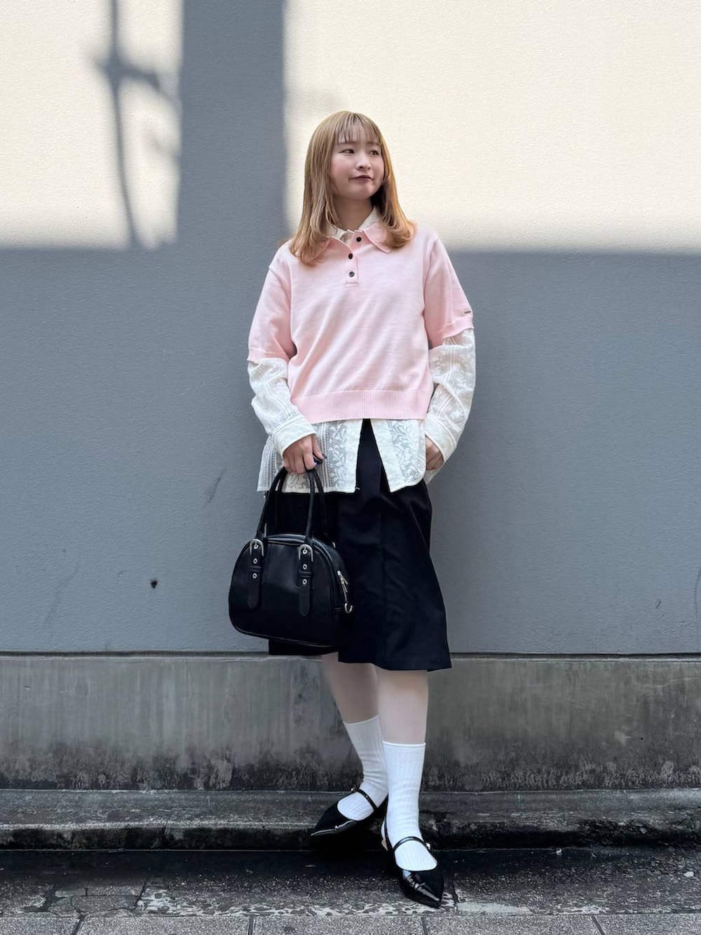 ブラック系のパンプス、ホワイト系のシャツ/ブラウス、ブラック系のスラックスを着用したレディースの春コーディネートの3枚目の写真
