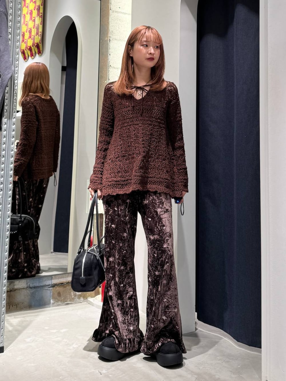 ブラウン系のその他パンツ、ブラック系のブーツ、ブラック系のショルダーバッグを着用したレディースの秋コーディネートの3枚目の写真