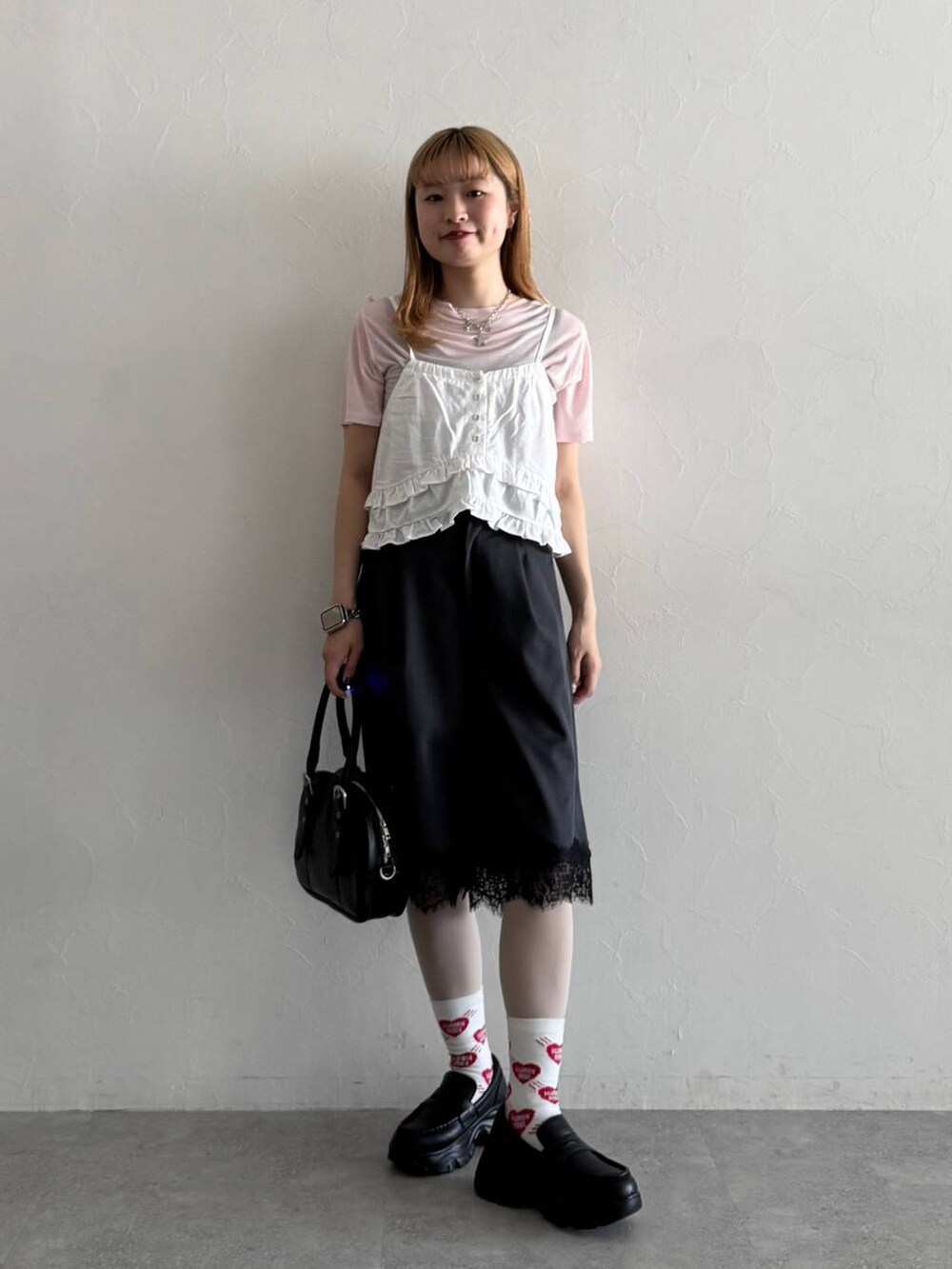 ブラック系のローファー、ブラック系のボストンバッグ、ピンク系のTシャツ/カットソーを着用したレディースの春コーディネートの4枚目の写真