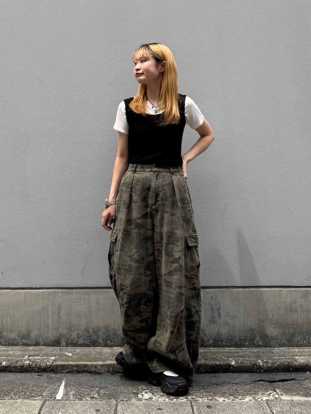 グリーン系のカーゴパンツ、ブラック系のタンクトップ、ブラック系のサンダルを着用したレディースの夏コーディネートの3枚目の写真
