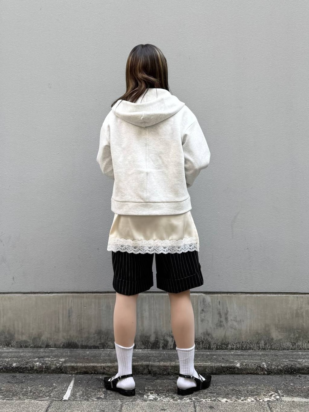 ブルー系のシャツ/ブラウス、ブラック系のパンプス、ホワイト系のパーカーを着用したレディースの春コーディネートの6枚目の写真