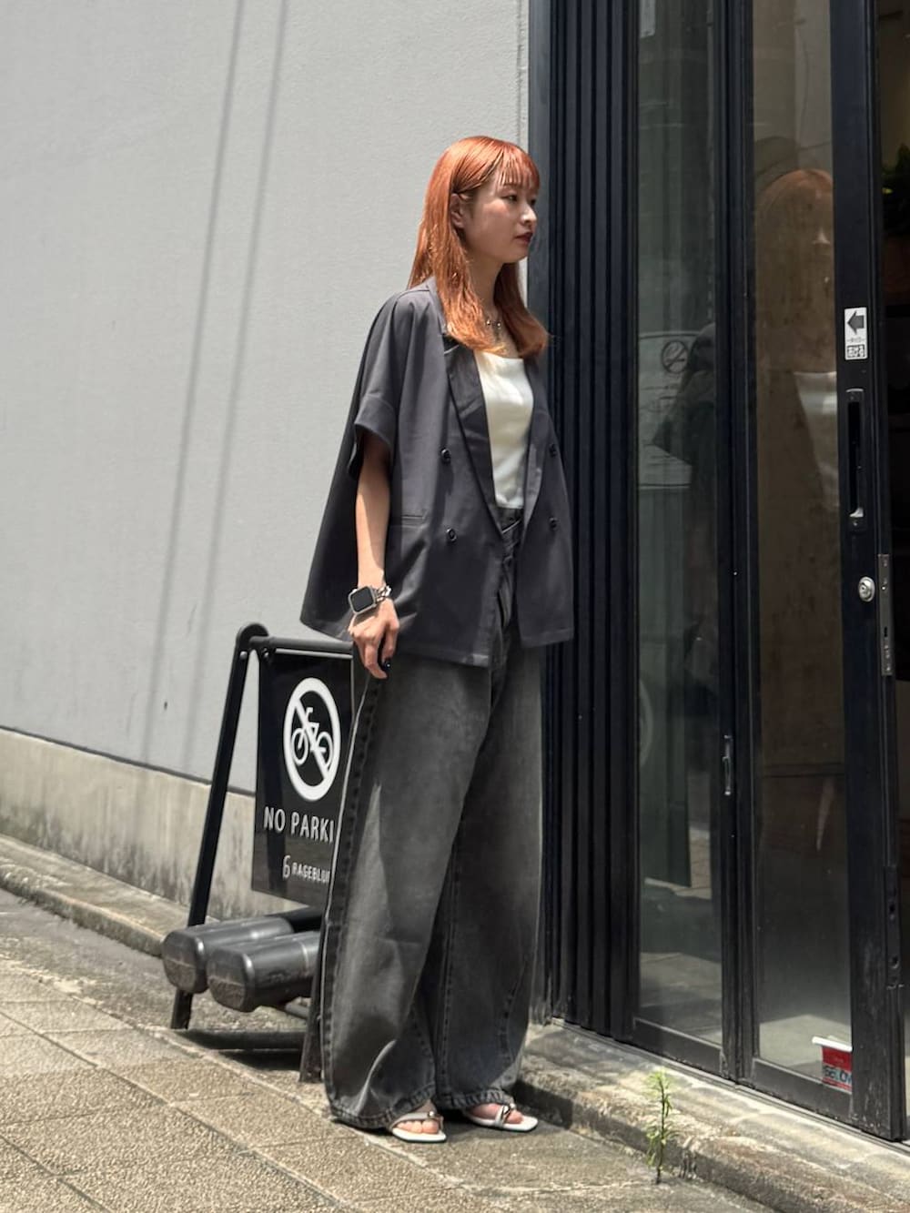 グレー系のデニムパンツ、グレー系のテーラードジャケット、ホワイト系のキャミソールを着用したレディースの夏コーディネートの6枚目の写真