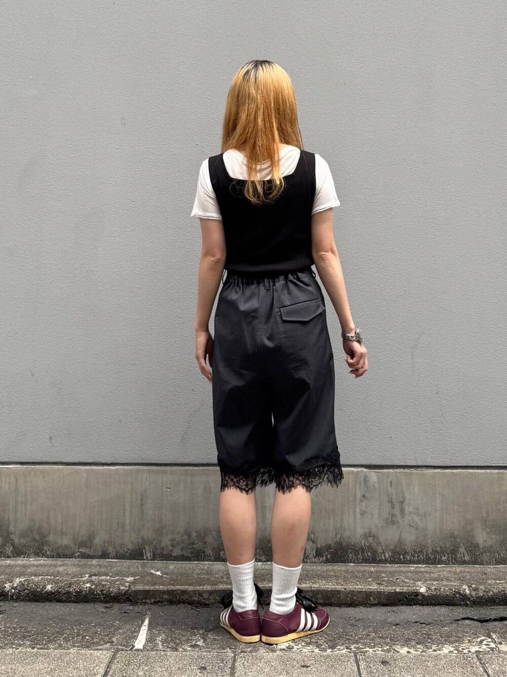 ブラック系のタンクトップ、ホワイト系のTシャツ/カットソー、ブラック系のスラックスを着用したレディースの夏コーディネートの6枚目の写真