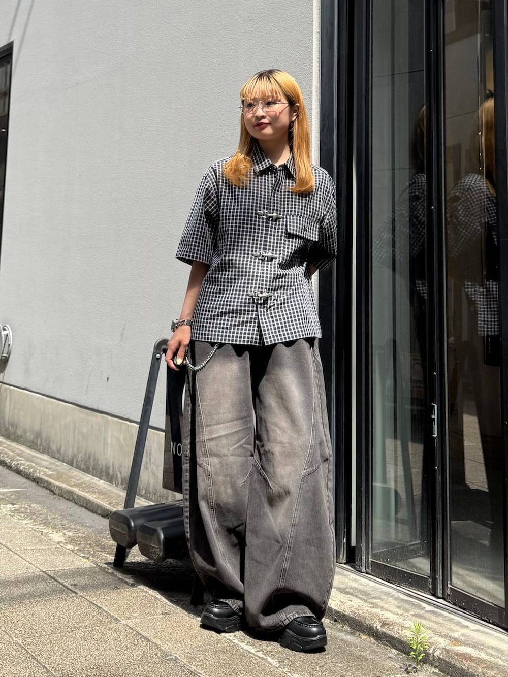 ブラック系のデニムパンツ、ブルー系のシャツ/ブラウス、グレー系のサングラスを着用したレディースの夏コーディネートの3枚目の写真
