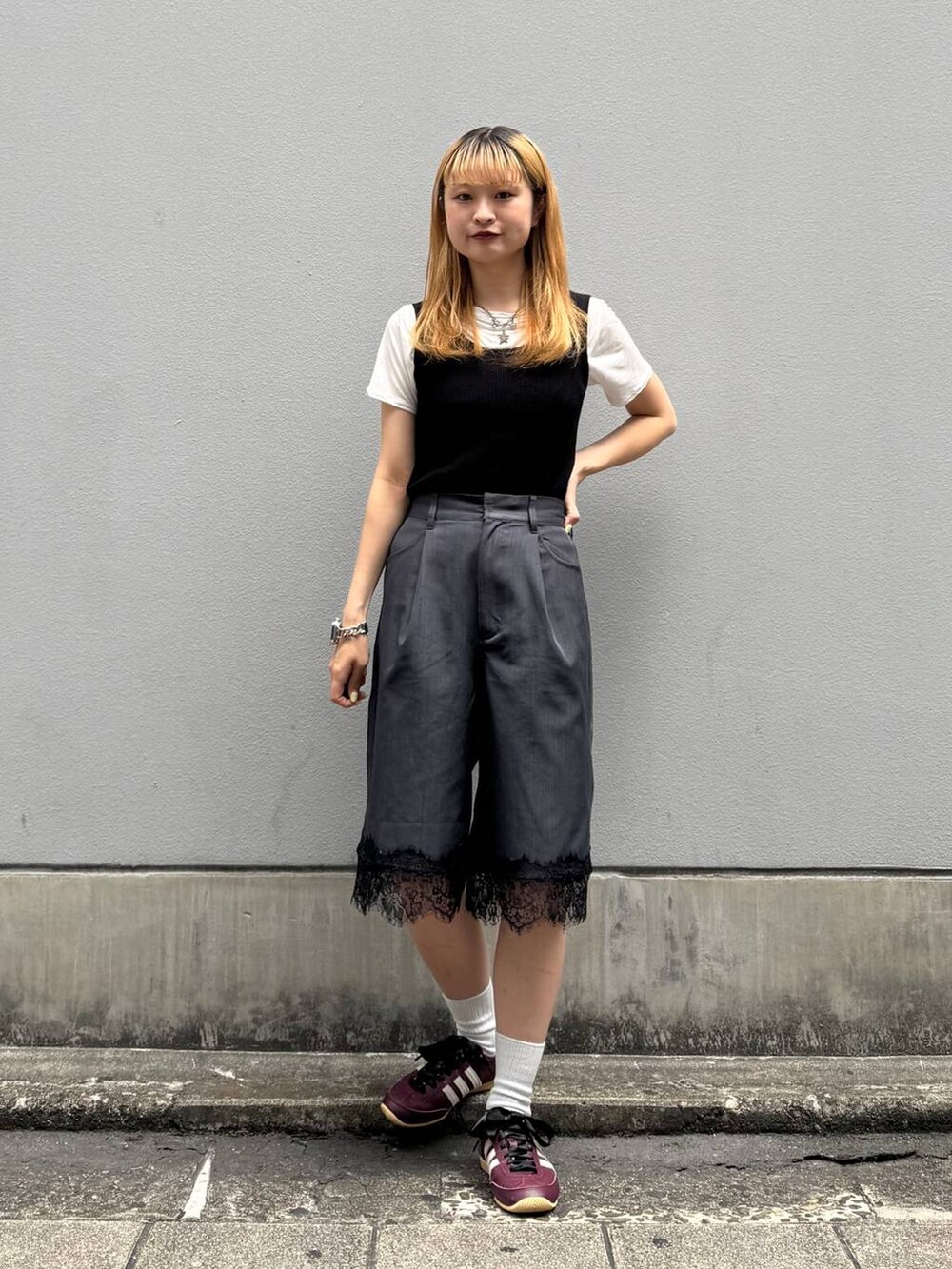 ブラック系のタンクトップ、ホワイト系のTシャツ/カットソー、ブラック系のスラックスを着用したレディースの夏コーディネートの3枚目の写真