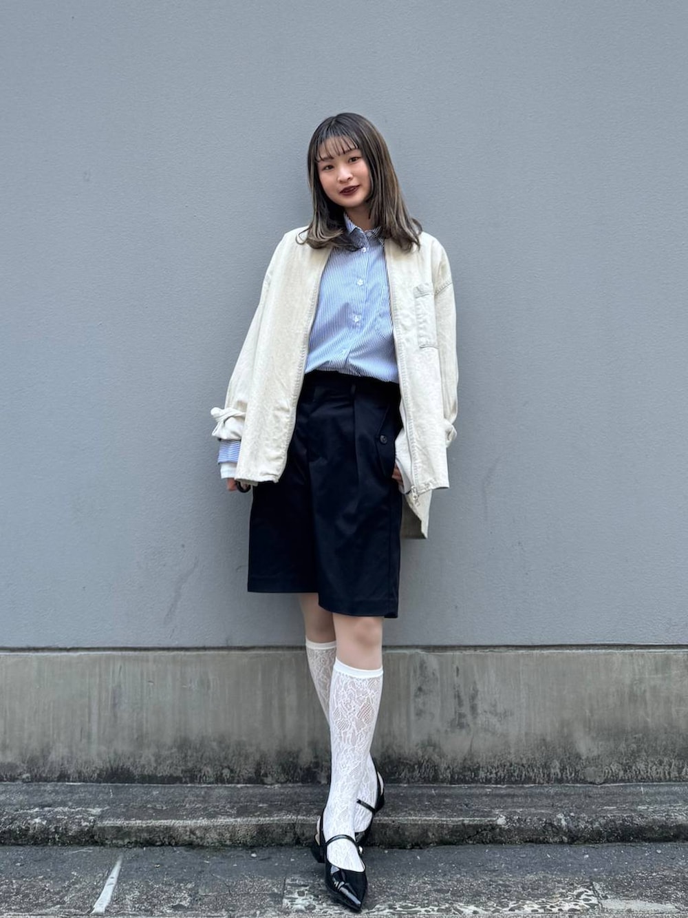 ブラック系のパンプス、ブラック系のスラックス、ブルー系のシャツ/ブラウスを着用したレディースの春コーディネートの5枚目の写真