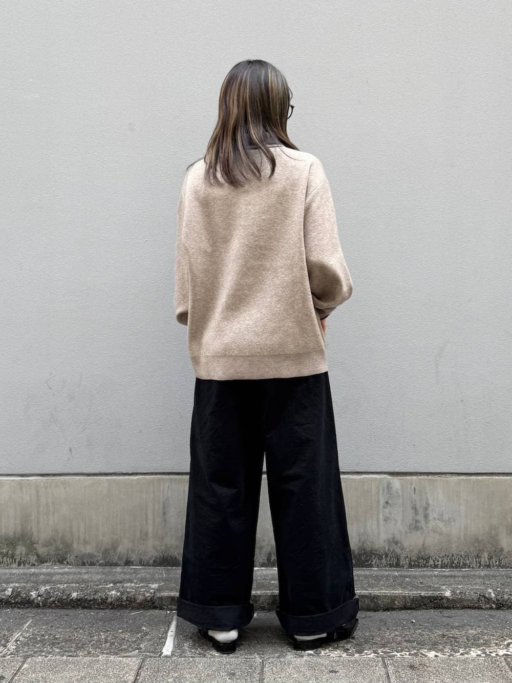 ブラック系のパンプス、ブラック系のチノパンツ、ベージュ系のニット/セーターを着用したレディースの春コーディネートの6枚目の写真