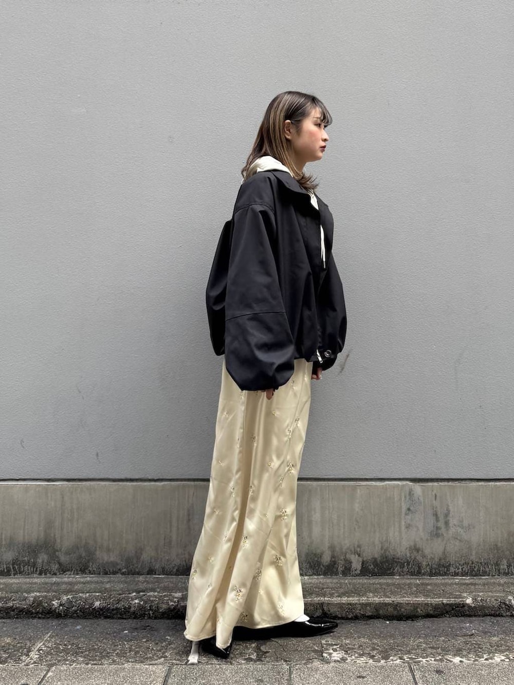 ブラック系のパンプス、ホワイト系のパーカー、ブラック系のブルゾンを着用したレディースの春コーディネートの6枚目の写真