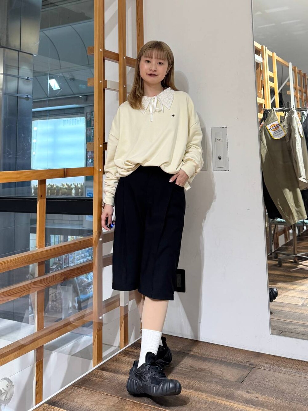 ホワイト系のスウェット、ブラック系のスラックスを着用したレディースの春コーディネートの2枚目の写真