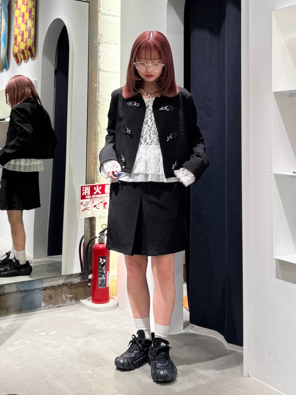 ホワイト系のTシャツ/カットソー、ブラック系のブルゾン、ブラック系のスカートを着用したレディースの秋コーディネートの5枚目の写真