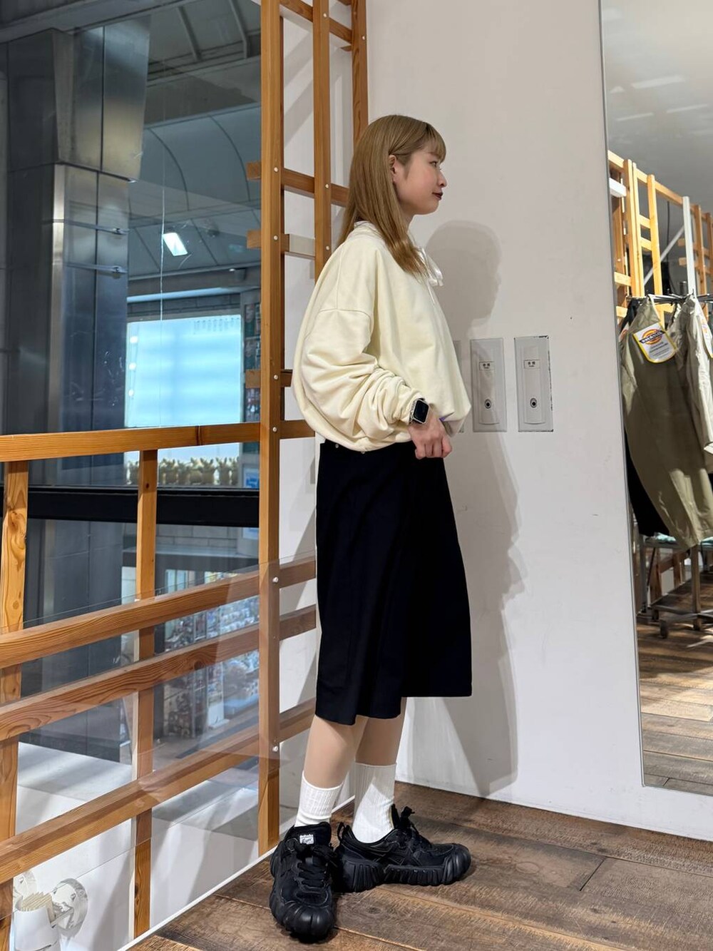 ホワイト系のスウェット、ブラック系のスラックスを着用したレディースの春コーディネートの7枚目の写真