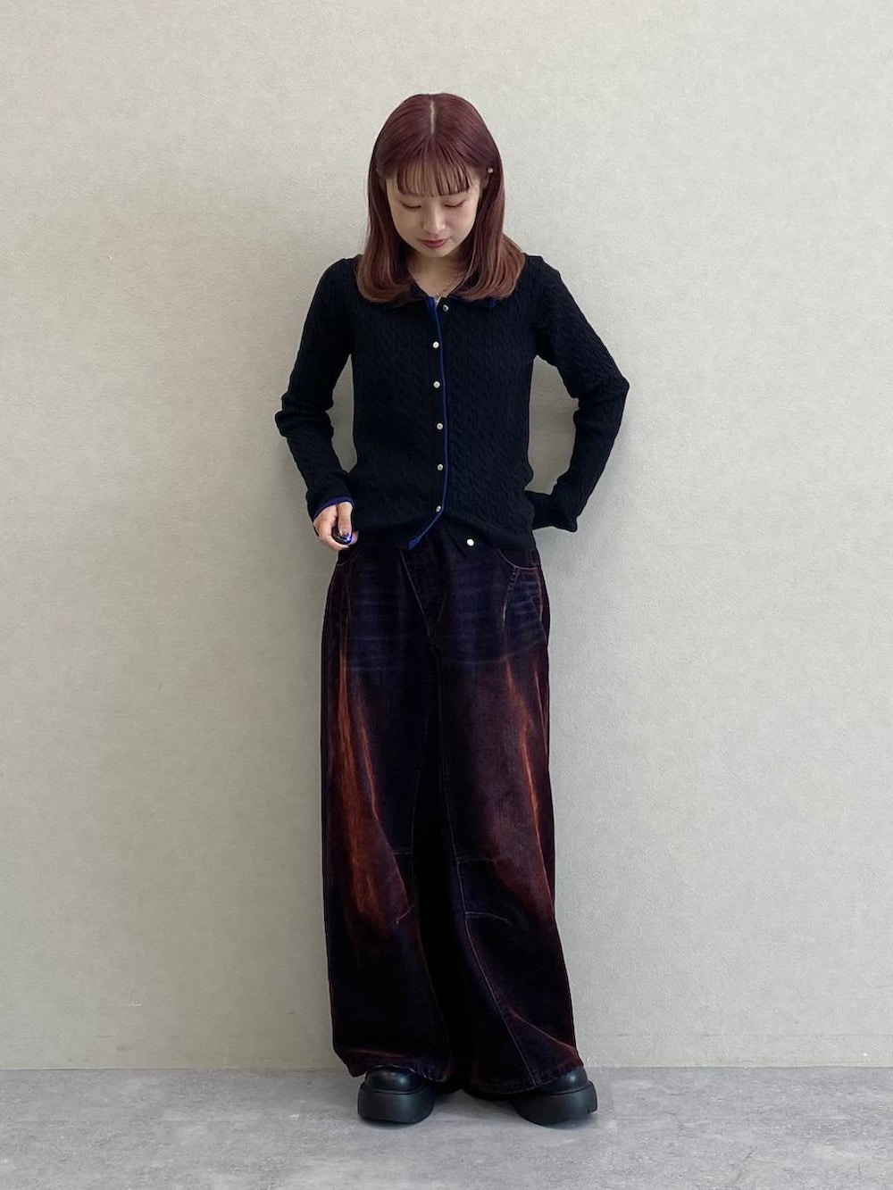 レッド系のデニムパンツ、ブラック系のニット/セーターを着用したレディースの秋コーディネートの4枚目の写真